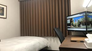 um quarto de hotel com uma cama e uma televisão numa secretária em Hotel Alpha-One Kitashinsaibashi em Osaka