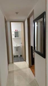 - un couloir d'une salle de bains pourvue de toilettes et d'un lavabo dans l'établissement Apartamento Armenia, à Armenia