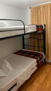 Ce dortoir comprend 2 lits superposés et une fenêtre. dans l'établissement Apartamento Armenia, à Armenia