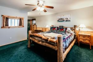 ein Schlafzimmer mit einem Holzbett und einem Deckenventilator in der Unterkunft Alameda Landing- Pool Table- Hot Tub- Relaxing Log Cabin in Big Bear Lake