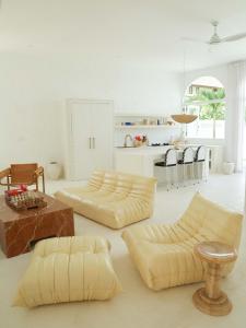 a living room with two couches and a kitchen at La Playa, Bali in Munggu