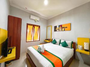 a bedroom with a large bed and a television at Homestay Simply Homy Jogja dekat Ambarukmo plaza in Yogyakarta