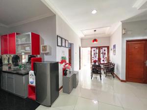 a kitchen with red cabinets and a dining room at Homestay Simply Homy Jogja dekat Ambarukmo plaza in Yogyakarta