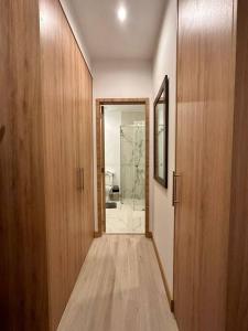een hal met houten kasten en een deur naar een badkamer bij Lujosa Suite piso 19 La Carolina in Quito