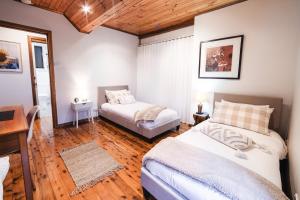 1 dormitorio con 2 camas, mesa y escritorio en Snooty Fox Bed &Breakfast en Hazelbrook
