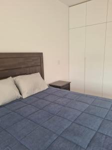 1 dormitorio con 1 cama con edredón azul en Miraflores habitación separada con privacidad dentro de departamento compartido en Lima
