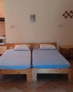 two twin beds in a room with a kitchen at Μαρία in Gera