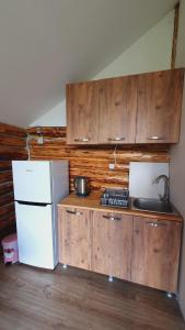 a kitchen with wooden cabinets and a white refrigerator at Echoes of the mountains in Mestia