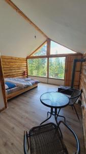 Zimmer mit einem Tisch, einem Bett und einem Fenster in der Unterkunft Echoes of the mountains in Mestia