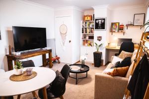 sala de estar con sofá y TV en Snooty Fox Bed &Breakfast, en Hazelbrook