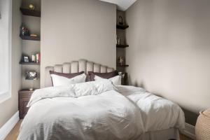 1 dormitorio con 1 cama con sábanas y almohadas blancas en Sophisticated apartment in Oslo en Oslo