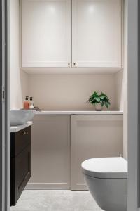 a white bathroom with a toilet and a sink at Sophisticated apartment in Oslo in Oslo