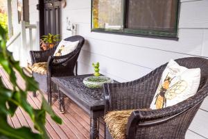 a porch with three wicker chairs and a table at Snooty Fox Bed &Breakfast in Hazelbrook