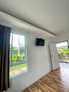 een kamer met een raam en een televisie aan de muur bij My Heaven Resort in Trang