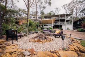 a fire pit in front of a house at Snooty Fox Bed &Breakfast in Hazelbrook