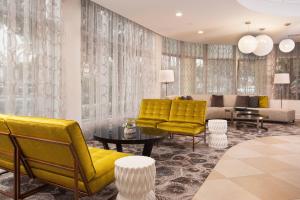 a living room with yellow chairs and a couch at Courtyard Miami Coral Gables in Miami