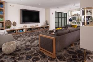 a living room with a couch and a tv at Courtyard Miami Coral Gables in Miami