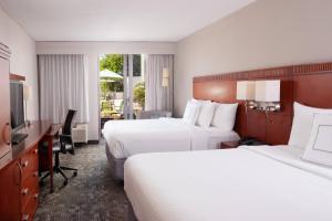 a hotel room with two beds and a desk at Courtyard Miami Coral Gables in Miami