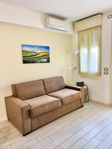 una sala de estar con un sofá marrón en una habitación en Appartamento Cipria, en Sirmione