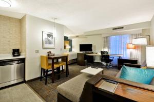 a hotel room with a couch and a living room at Residence Inn by Marriott Jacksonville Airport in Jacksonville