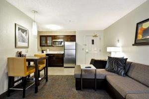 a living room with a couch and a table at Residence Inn by Marriott Jacksonville Airport in Jacksonville
