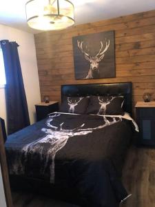 sypialnia z łóżkiem z głową jelenia w obiekcie Le petit chalet a Chertsey w mieście Chertsey