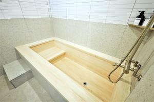 a bath tub with a wooden floor in a bathroom at De Lamour Hotel in Tongyeong