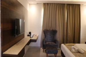 a hotel room with a bed and a desk and a chair at Meera Madhav Resort in Vrindāvan +22 photos