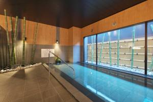 uma piscina num edifício com uma grande janela em Hotel Route Inn Grand Nakano Obuse em Nakano