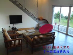 un soggiorno con tavolo, sedie e TV di Sun Motel a Chenggong