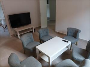 a room with chairs and a white table and a tv at O'Couvent - Appartement 441 - 3 chambres - 97 m2 - Quatrième étage in Salins-les-Bains