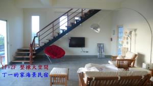 a living room with a staircase and a tv at Sun Motel in Chenggong