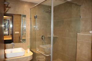 a bathroom with a glass shower with a sink at Meera Madhav Resort in Vrindāvan