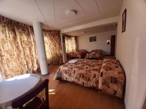 a hotel room with two beds and curtains at HOSTAL SUMITA HOUSE_INN in Puno