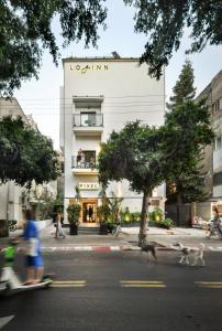 Un bâtiment avec des gens qui courent devant lui dans l'établissement Pixel Dizengoff Square - Smart Hotel by Loginn Tel Aviv, à Tel Aviv