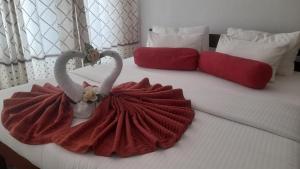 a bed with two swans on it with red pillows at Discovery Retreat Blackwood in Haputale