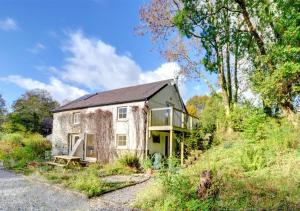 a stone house on the side of a hill at Felin Fach in Pumpsaint