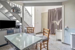 Charming duplex near Paris - Welkeys في بولون بيانكور: غرفة معيشة مع طاولة وكراسي زجاجية