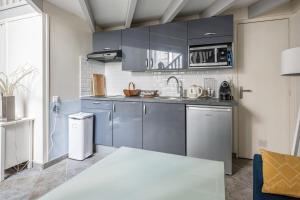 uma cozinha com armários azuis e um lavatório em Charming duplex near Paris - Welkeys em Boulogne-Billancourt