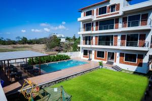 an apartment building with a swimming pool and a yard at Lotus The Lake View Resort in Alibaug