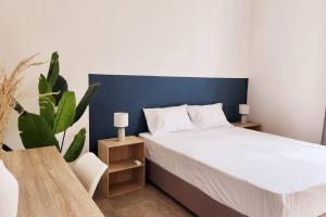een slaapkamer met een wit bed en een plant bij La Maison d'Isa in Albion