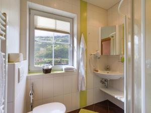 a bathroom with a sink and a toilet and a window at Aparthotel Gallahaus in Zell am Ziller