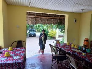 a man standing in a room with two tables at Magharibi House in Nungwi