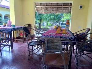 uma sala de jantar com uma mesa e cadeiras e uma janela em Magharibi House em Nungwi