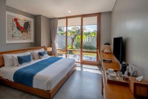 a bedroom with a bed and a sliding glass door at Ecozy Dijiwa Canggu in Canggu