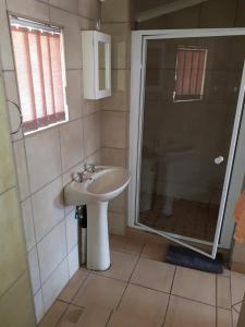 a bathroom with a sink and a shower at Forget me Not Lydenburg in Lydenburg