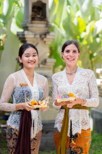 two women standing next to each other holding food at Ecozy Dijiwa Canggu in Canggu