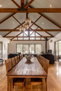 uma sala de jantar com uma mesa de madeira e cadeiras em Huge house Your Hunter Valley Wine Staycation ! em Pokolbin