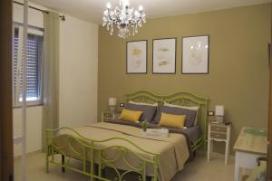 a bedroom with a green bed and a chandelier at SOLEMARE Rooms - CAMERA SUGHERO in Olbia
