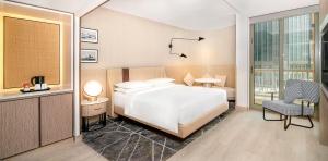 a hotel room with a bed and a chair at Sheraton Abu Dhabi Hotel & Resort in Abu Dhabi